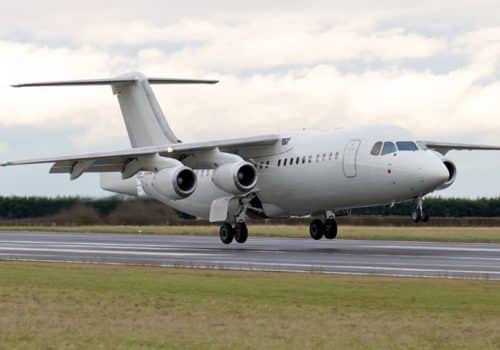Avion Avro RJ85 blanc au décollage de la piste