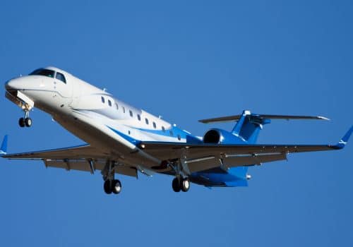 Embraer Legacy 600 de couleur bleue en train d'atterrir sur un aéroport.